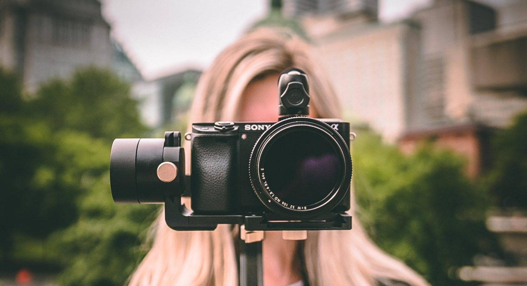 selective focus photography of woman holding camera gimbal